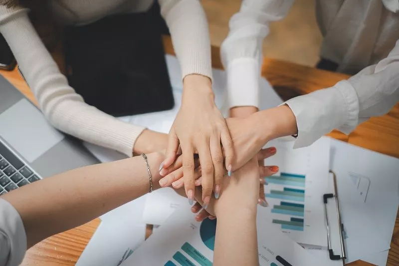 positive-diverse-business-team-putting-their-hands-top-each-other-showing-unity-teamwork.jpg кисти рук